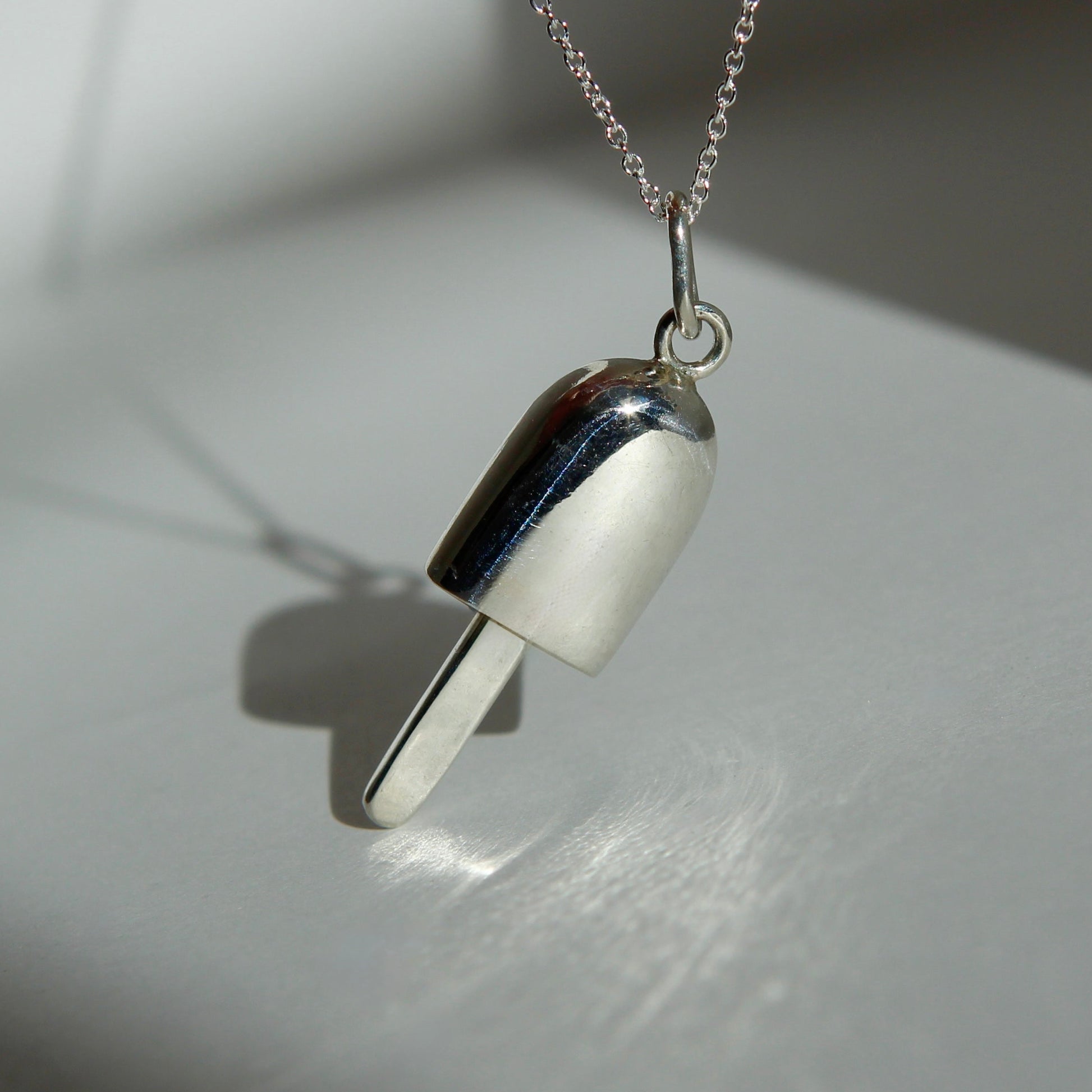 Silver necklace with a unique pendant on a light surface